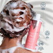 Mujer aplicando el champú Special Curls Valquer en el cabello rizado, fórmula 0% sulfatos, siliconas, colorantes y sal, 100% vegana y dermatológicamente testada
