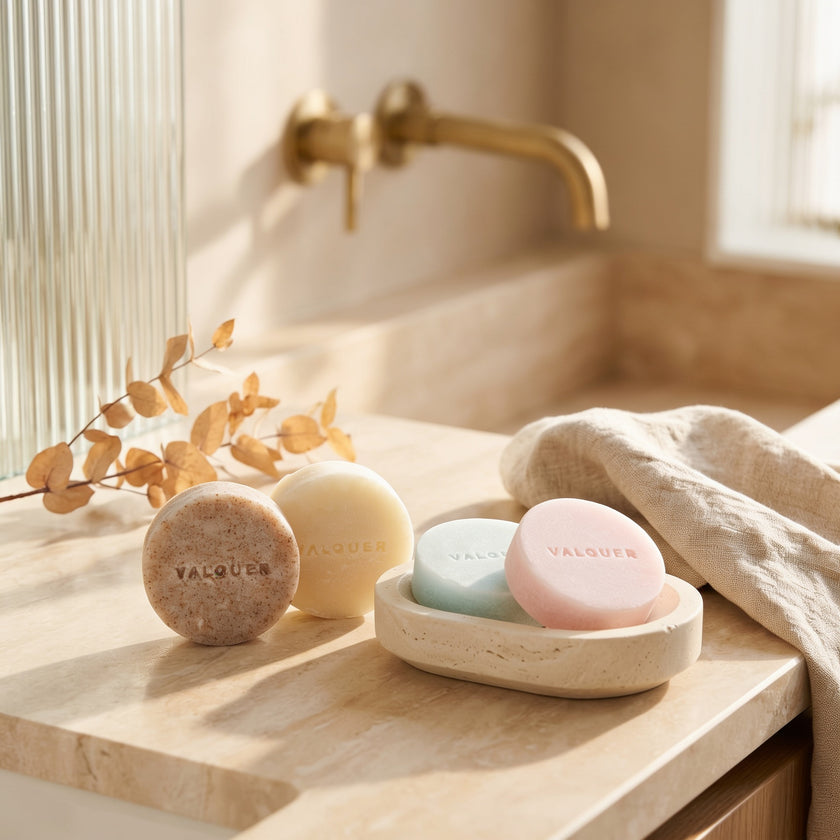 Cosméticos sólidos de Valquer para la higiene facial, corporal y capilar colocados en un baño.