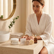 Mujer con rutina facial Valquer de crema de colágeno vegetal, sérum de vitamina C y limpiadores sólidos.