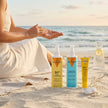 Mujer aplicando protección solar en la playa junto al Trío Solar Completo de Valquer para rostro, cuerpo y cabello.