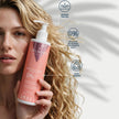 Mujer aplicando el booster Special Curls Valquer en el cabello rizado, fórmula 0% sulfatos, siliconas, colorantes y sal, 100% vegana y dermatológicamente testada