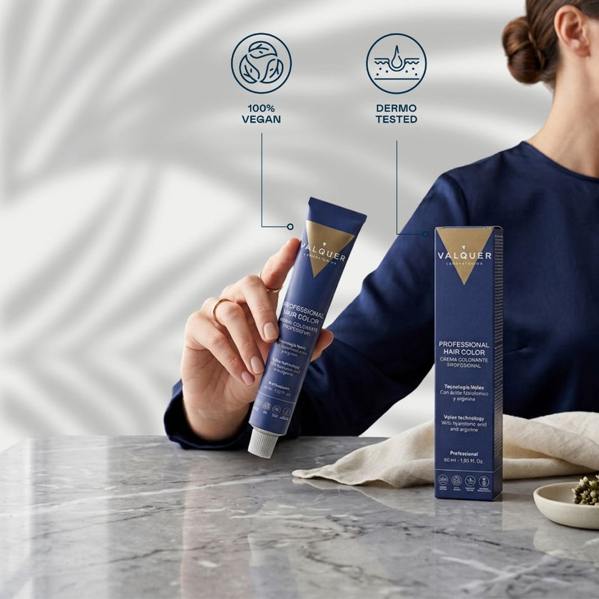 Persona sosteniendo un tubo de coloración Valquer junto a su caja, con sellos de fórmula vegana y test dermatológico.